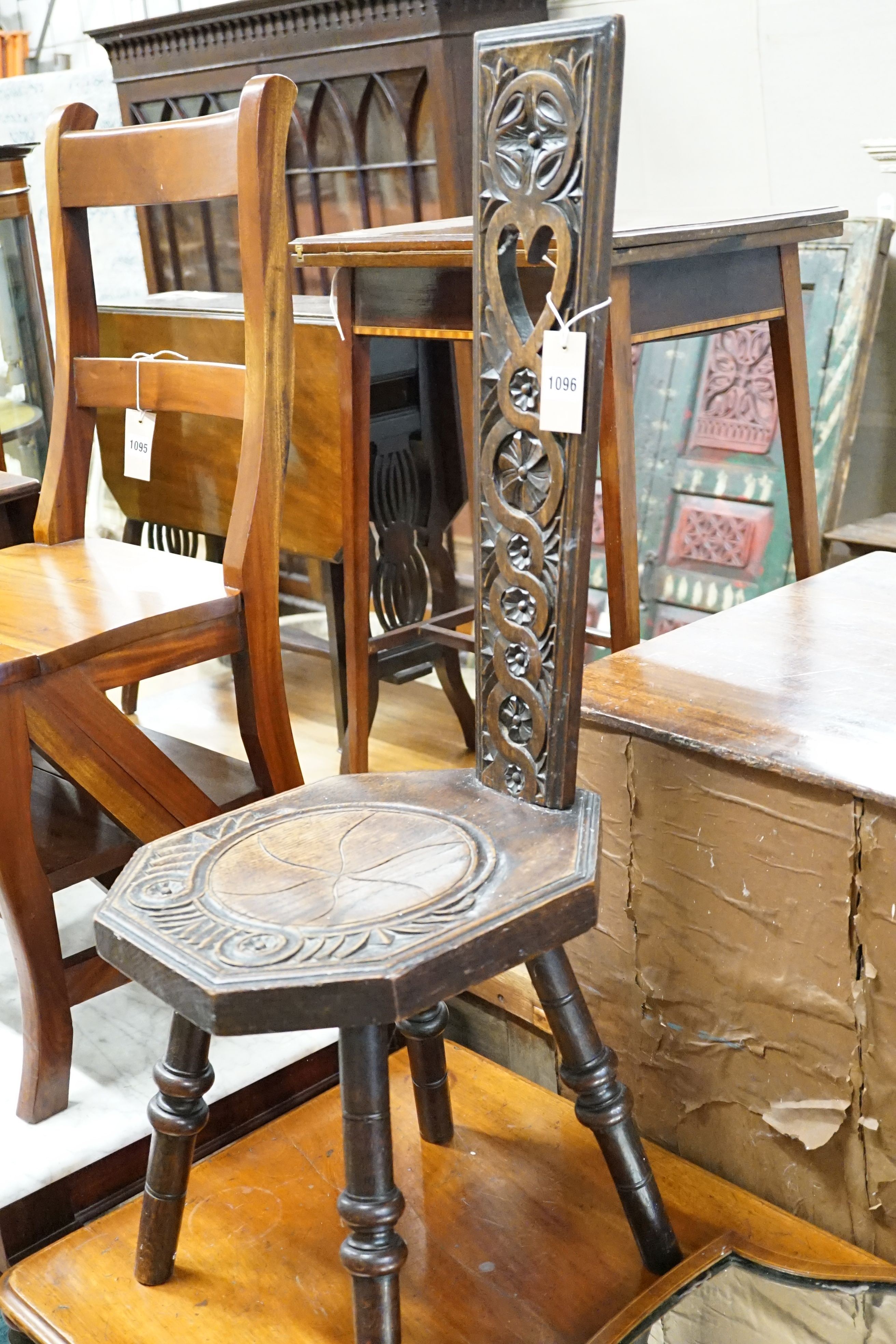 An Edwardian inlaid mirror and a carved stool.
